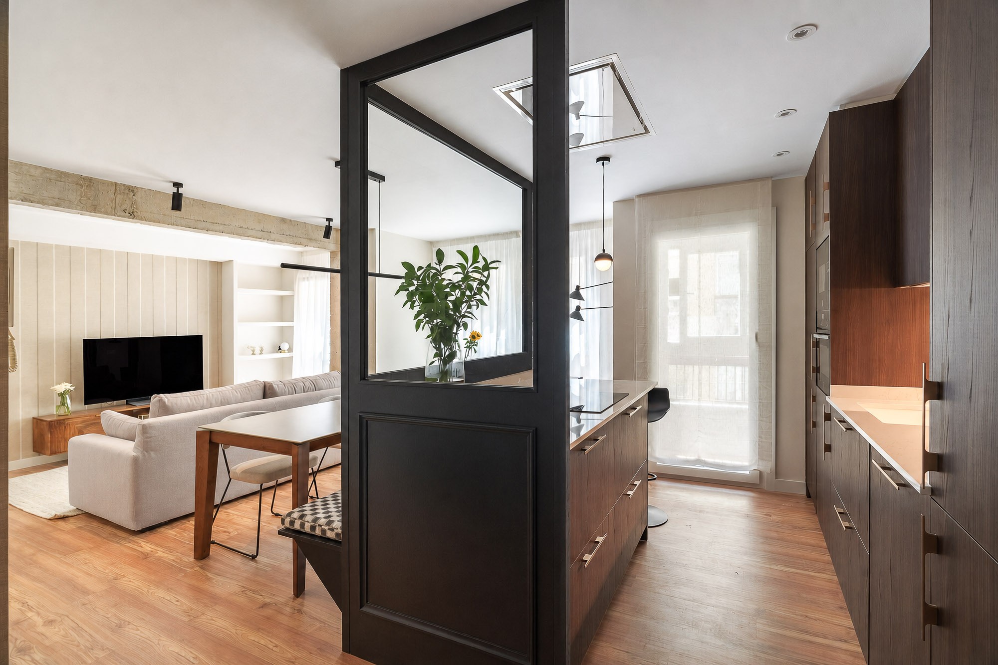 Cocina y salón con cerramiento de vidrio y acero negro
